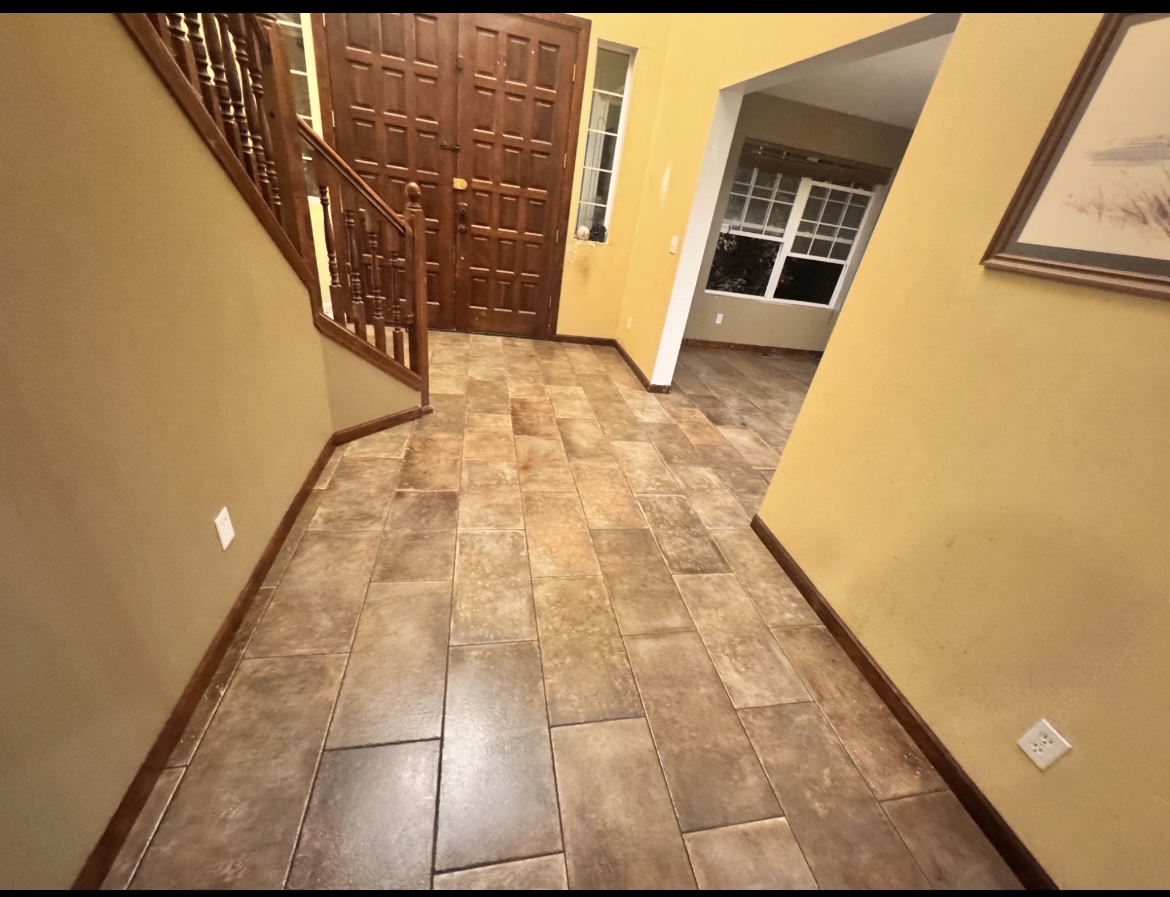Tiled entryway and foyer floor with staircase