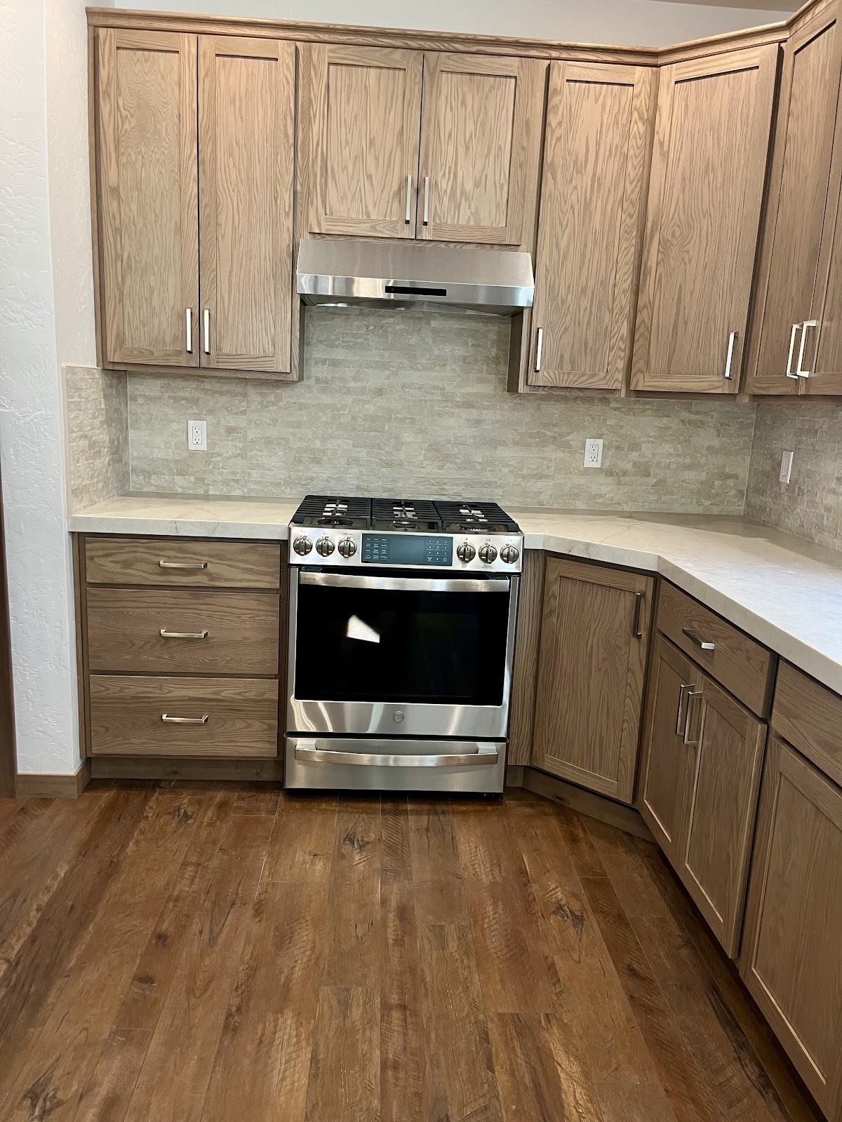 Kitchen with marble-look tile backsplash, new cabinets and wood floor